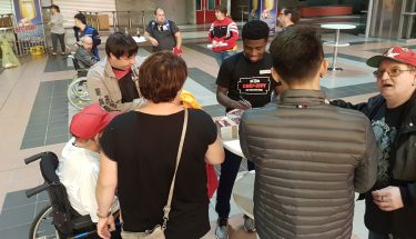 Manfred Osei Kwadwo schreibt Autogramme bei der Autogrammstunde für Fans mit Handicap