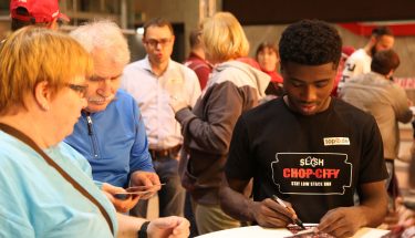 Manfred Osei Kwadwo schreibt Autogramme bei der Autogrammstunde für Fans mit Handicap