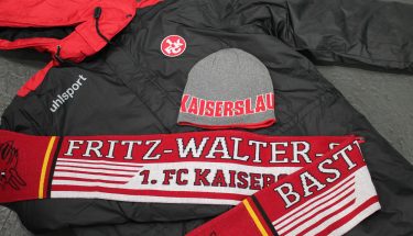Eine FCK Jacke, Mütze und ein Schal im Fanshop welche zur Monatsaktion angeboten werden